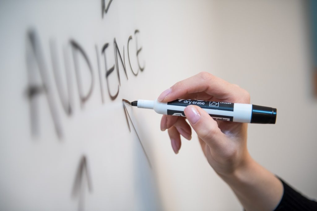 A business owner planning for audience marketing writing on a strategy board