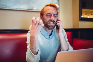 Frustrated freelancer trying to explain his point to a client over the phone