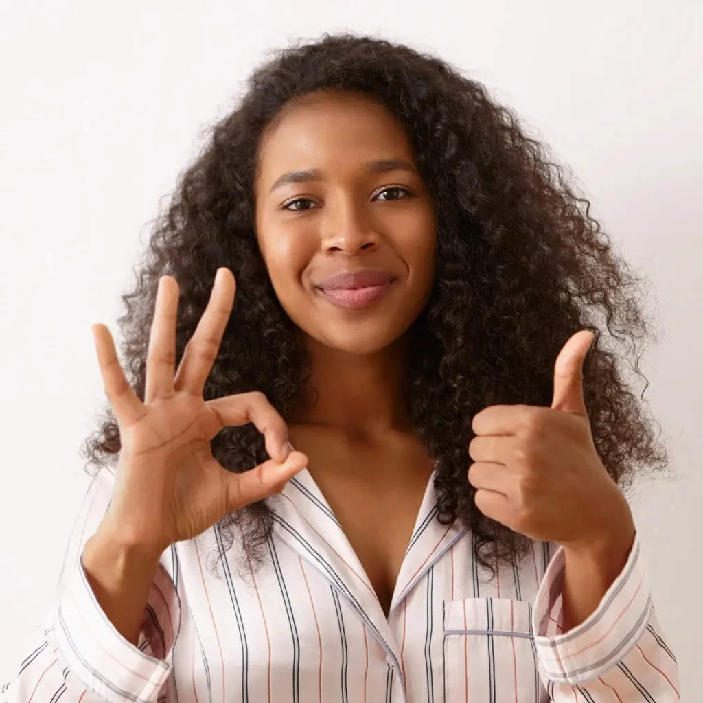 A woman doing a thumbs up and the "okay" sign