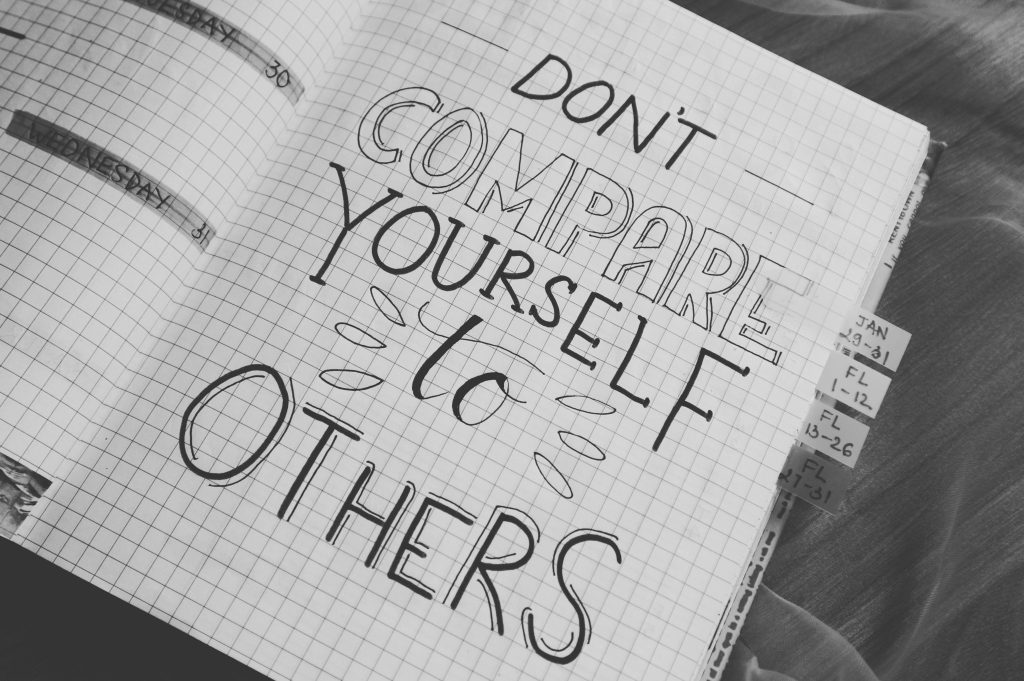 A book with the words written on it "Don't compare yourself to others"