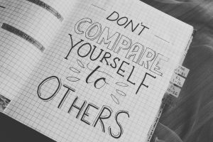 A book with the words written on it "Don't compare yourself to others"